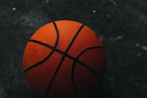 Dirty street basketball on a dark concrete background. photo