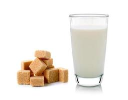 glass of milk and cubes of cane sugar isolated on white background photo