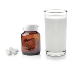 pill and glass of milk isolated on white background photo