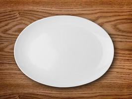 Empty white plate on wooden table photo