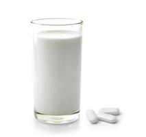 Pastilla y vaso de leche aislado sobre fondo blanco.