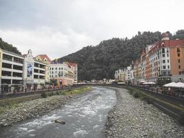 Mountain river an beautiful buildings in Roza Khutor, Sochi, Russia, 2019 photo