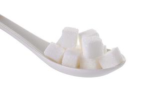 Cubitos de azúcares en una cucharadita aislado sobre fondo blanco.