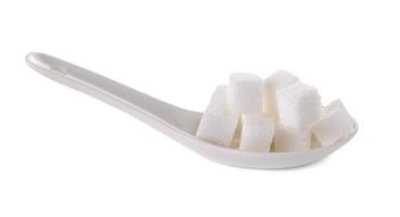 Cubo de azúcares en cuchara blanca aislado sobre fondo blanco.