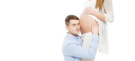 El hombre está escuchando al bebé en el vientre aislado sobre fondo blanco. foto