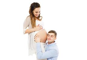 Young attractive couple pregnant mother and happy father who listening pregnant belly photo