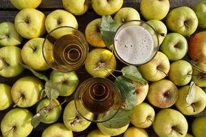 tres vasos de sidra de manzana y frutas amarillas sobre la mesa. foto