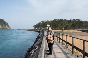 Aged couple 70-80 walking in Rodiles, following a wooden path next to the river photo