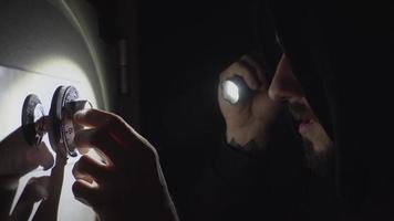 The thief is trying to open the safe in the night video