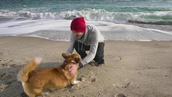 mannetje spelen met hond op het strand video