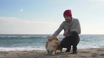 mannetje spelen met hond op het strand video