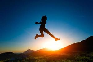 Girl jumps during a sunset in the mountains