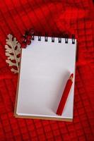 Notepad with blank space for text. White sheet on a red background. photo