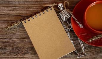 Halloween card with skeleton and notepad. Autumn background. photo