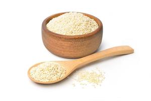 White sesame seeds in wooden bowl and wooden spoon isolated on white background photo