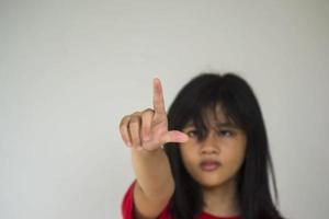 A beautiful young girl pinting with her index finger photo