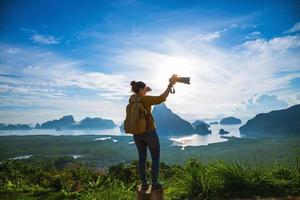 fotógrafos de turismo femenino viajan en la montaña. paisaje hermosa montaña en el mar en el mirador samet nangshe. bahía de phang nga, aventura de viaje, viaje a tailandia, turístico foto