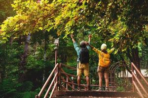lover woman and man asian travel nature.Travel relax. Walking and studying nature in the forest. Thailand