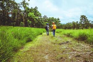 Amante mujer y hombre asiático viajes naturaleza. viajar relajarse. caminar estudiar el camino naturaleza en el bosque foto