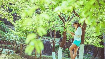 naturaleza de viaje de mujer asiática. viajar relajarse. libro de lectura en el parque. en verano. foto