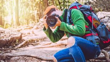 fotografo mujeres asiáticas viajando fotografia naturaleza. viaje relajarse en el paseo de vacaciones en el bosque. tailandia foto