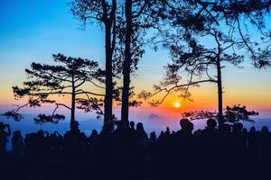 gente viendo amanecer en la mañana. los turistas viajan relajarse en las vacaciones. fotografiar el amanecer de la mañana entre la gente. tailandia foto