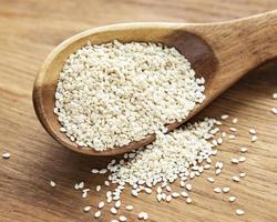 Sesame seeds in a spoon on a rustic table photo