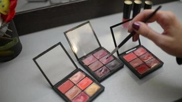 maquilleuse prenant une ombre de couleur de la palette d'ombres de maquillage video