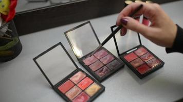 maquilleuse prenant une ombre de couleur de la palette d'ombres de maquillage video