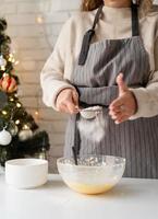 Mujer sonriente en la cocina para hornear galletas de Navidad foto