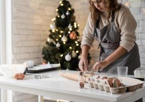 Mujer sonriente en la cocina para hornear galletas de Navidad foto