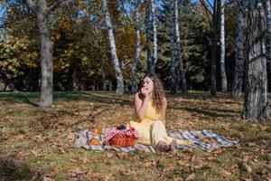 Bella mujer en vestido amarillo en un picnic foto