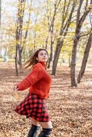 young happy woman walking in autumn forest