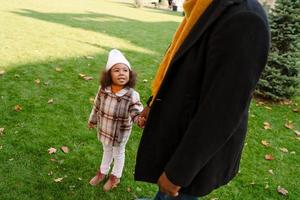 Abuelo negro hablando con su nieta durante caminar al aire libre foto