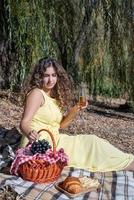 Bella mujer en vestido amarillo en un picnic foto