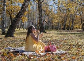 Beautiful woman in yellow dress on a picnic photo