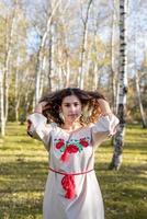 Bella mujer en ropa de traje tradicional nacional ucraniano en el bosque