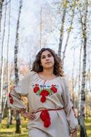beautiful woman in ukrainian national traditional costume clothes in forest photo
