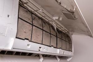 Photo of the air conditioner with the cover open showing the dust clinging to the filter element, before removing it for cleaning.