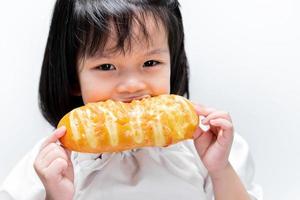 Child are happy to eat soft sweet bread. Children's snacks. Girl holding homemade bread. photo