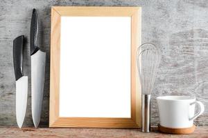 marco de madera vacío y accesorios de cocina en una mesa de madera. maquetación para su diseño foto