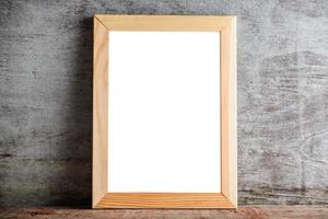 wooden frame on a wooden table on a gray wall. Template layout for adding a design or an inscription photo