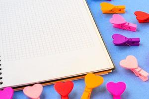 white notebook for notes and many hearts on a blue background. photo