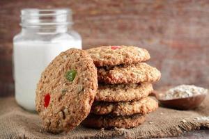 Homemade oat biscuits and glass og milk on a wooden background photo
