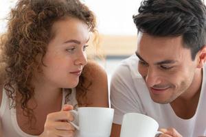 Happy couples relaxing in the white bedroom Of the apartment photo