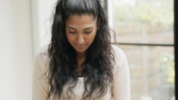 Woman with head down talking and looking up smiling into camera lens video