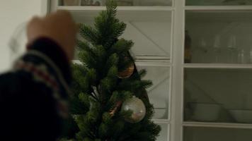 man kerstboom versieren met lichtjes met instructies van vrouw video
