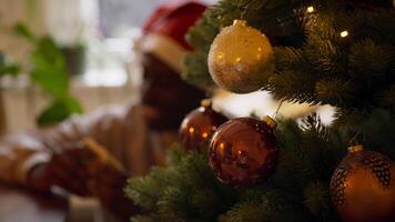 uomo con cappello di natale che gioca a carte vicino all'albero di natale video