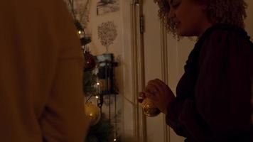 kvinna och flicka letar efter utrymme att dekorera julgran med grannlåt video