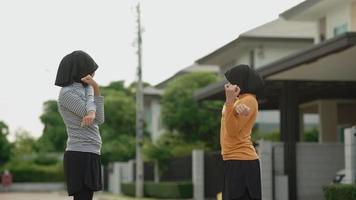 Two Muslim teenage girls are having fun jogging. In her village in the evening video